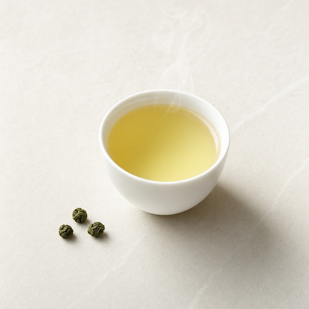 A small white porcelain cup of pale jade-yellow Cloud Ridge Oolong with a faintly warmer amber edge
