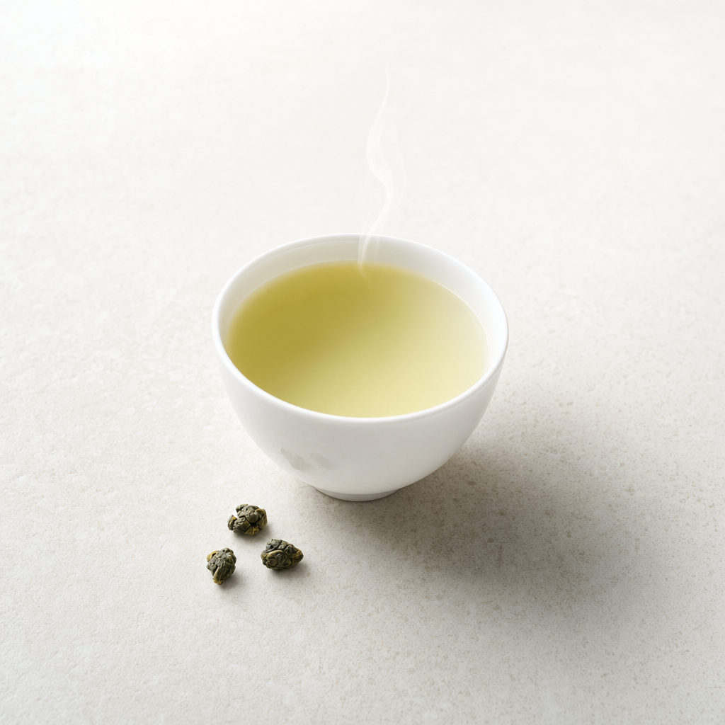 A small white porcelain cup of pale green-yellow Cloud Bridge Oolong with a clean middle tone between the Ridge's jade and the Foothill's amber
